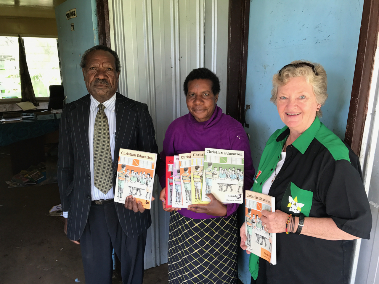 Leme Yaka, Robin Lakari, principal of Tsak Raiagama Lutheran Primary School, and Jan Luedtke with Barbara Arnold CRE resource.